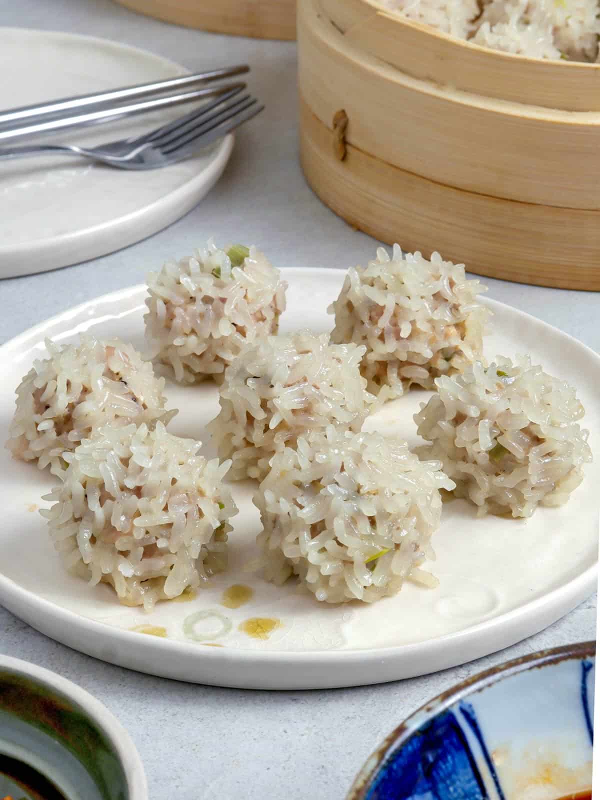 Chinese Pearl Balls on a plate and a steamer basket on the side