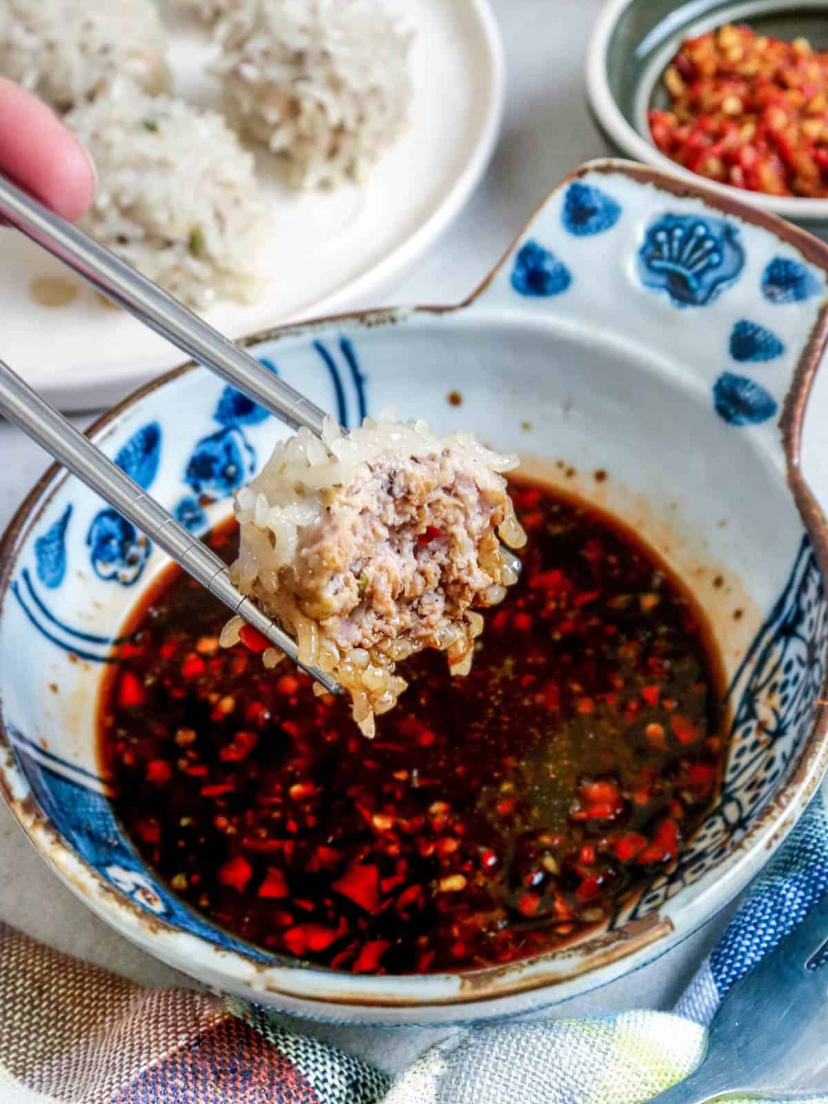 dipping porcupine meatballs in chili sauce