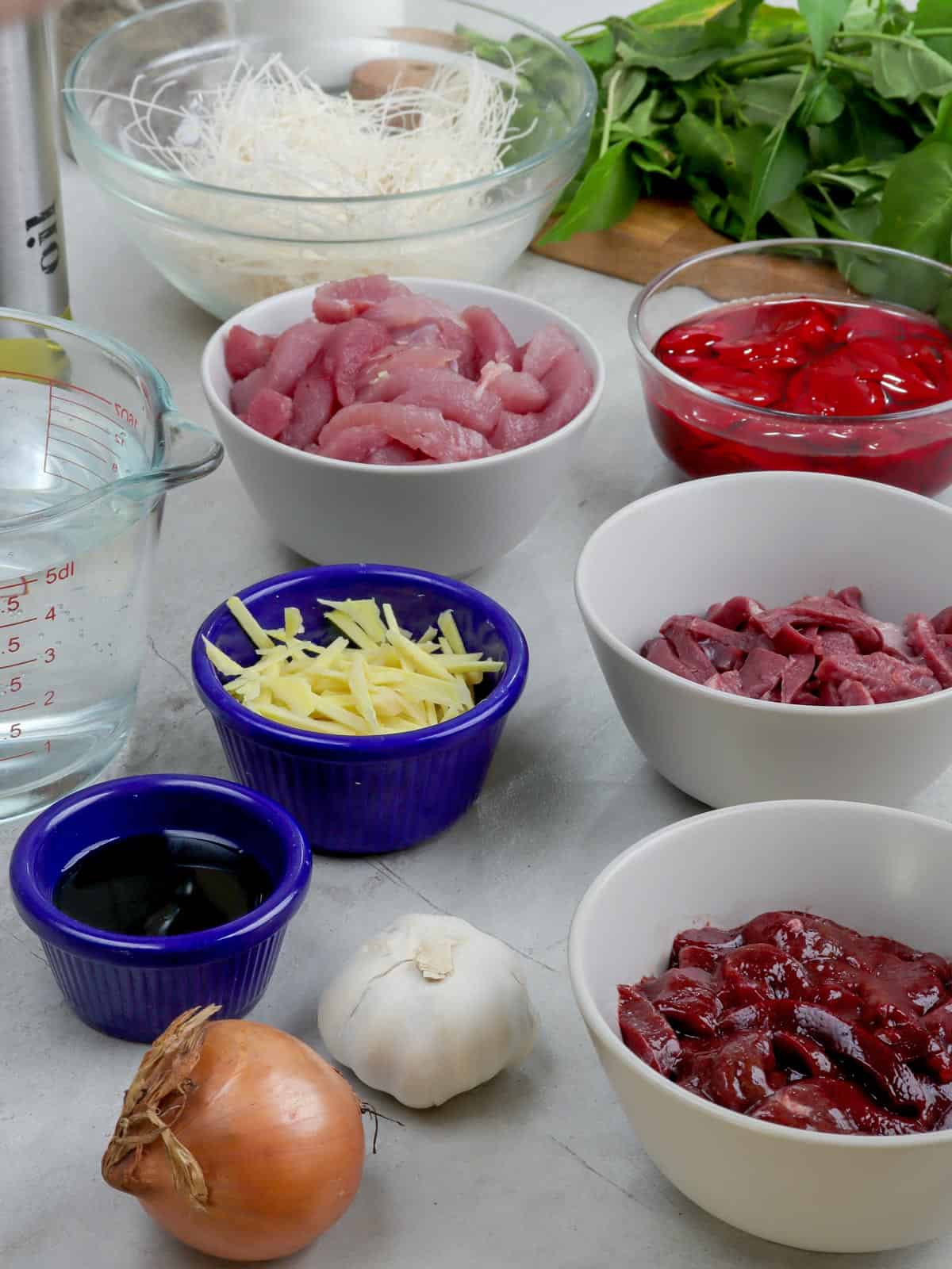 pork, pork heart, liver, miswa, blood, onion, garlic, spinach, water, ginger, fish sauce in bowls.