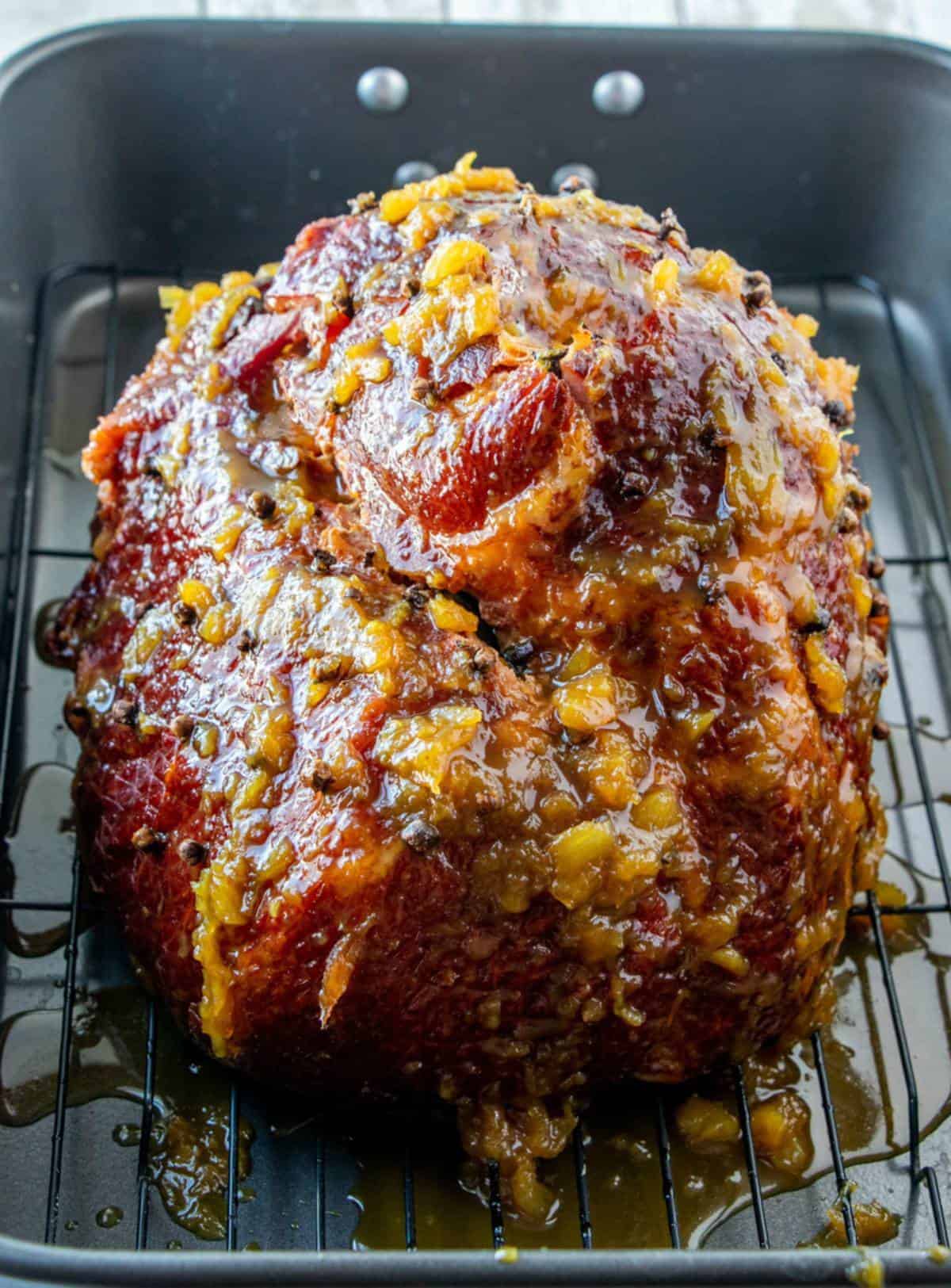 bone-in ham brushed with pineapple glaze on a roasting rack
