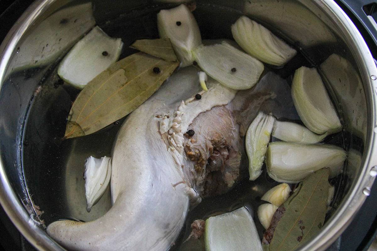 cooking ox tongue with aromatics in a pot