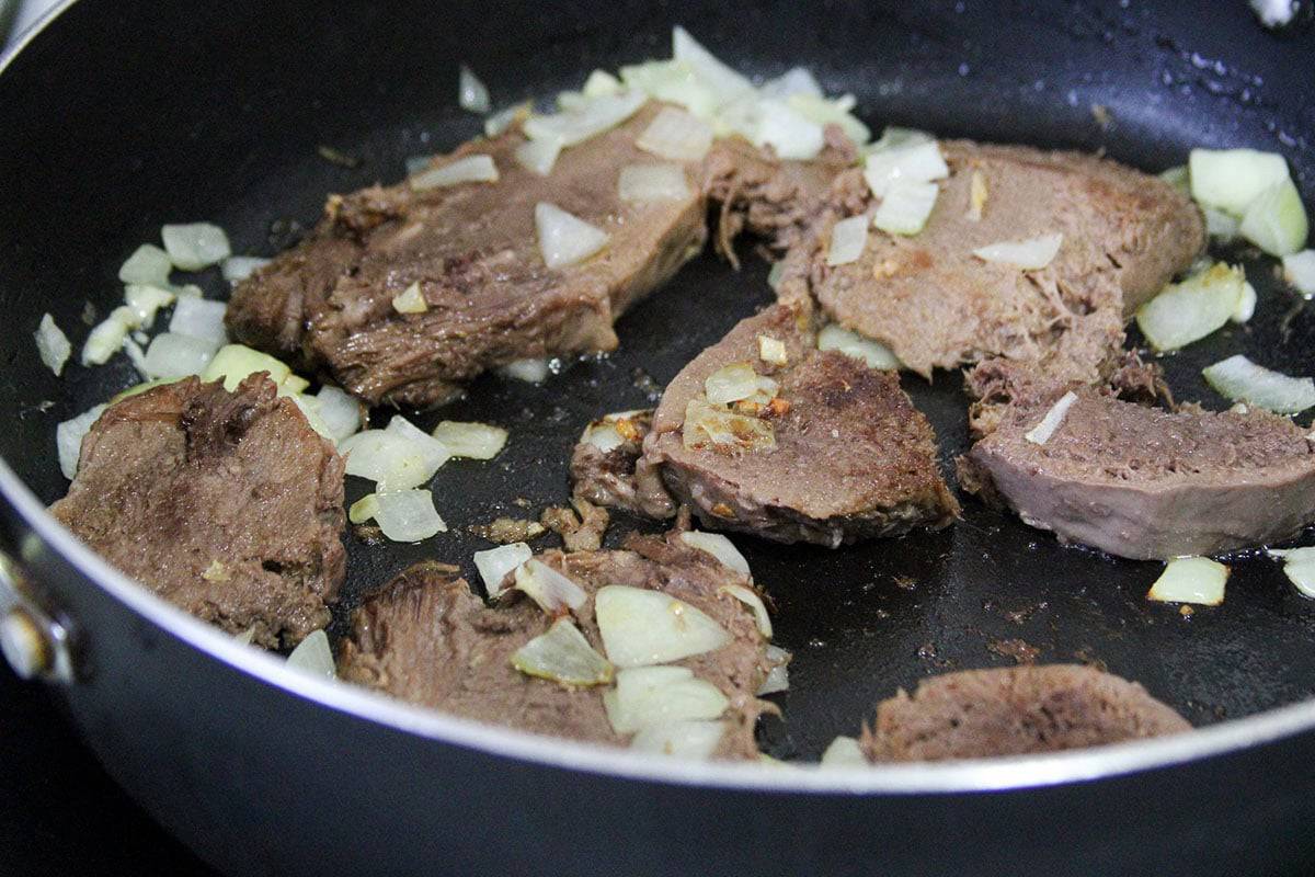 browning sliced tongue in a pan