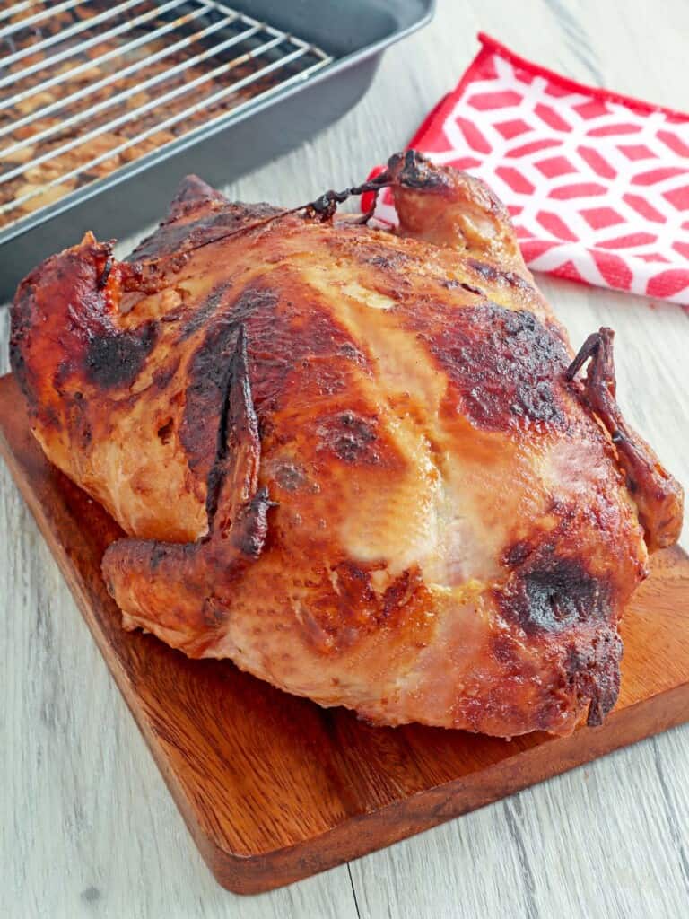 whole Filipino-stuffed chicken on a cutting board