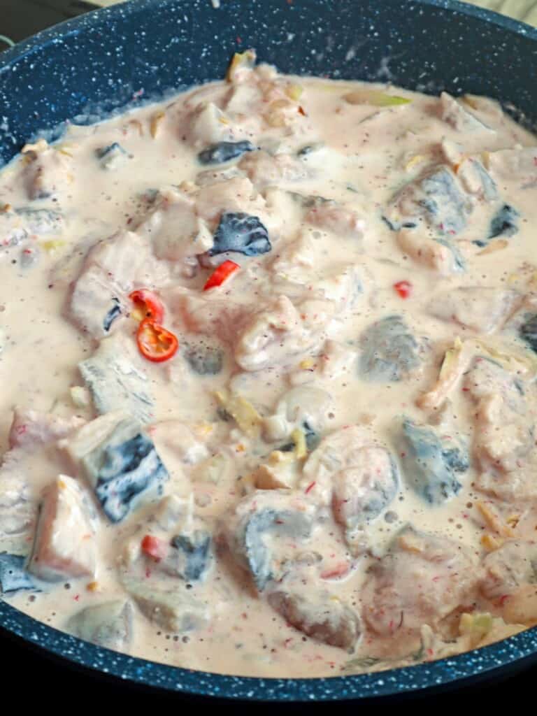cooking bangus with coconut milk in a pan