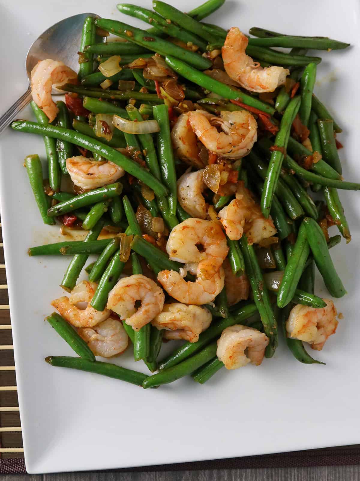 string bean shrimp stir fry on a white serving platter