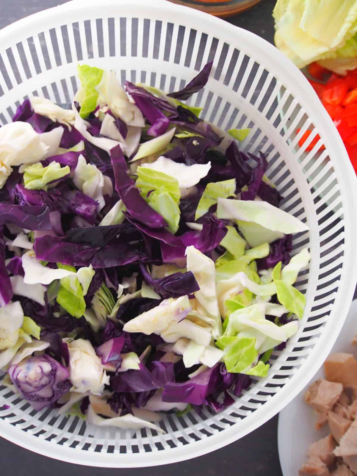 chopped red and green cabbage in a colander.