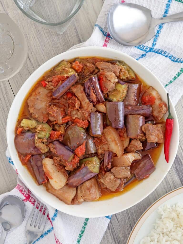 eggplant stew with shrimp paste and pork belly in a white serving bowl