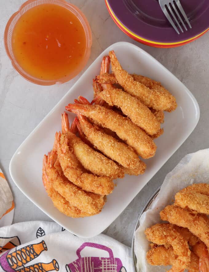 Coconut Shrimp on a serving platter with a small bowl of sweet chili sauce on the side