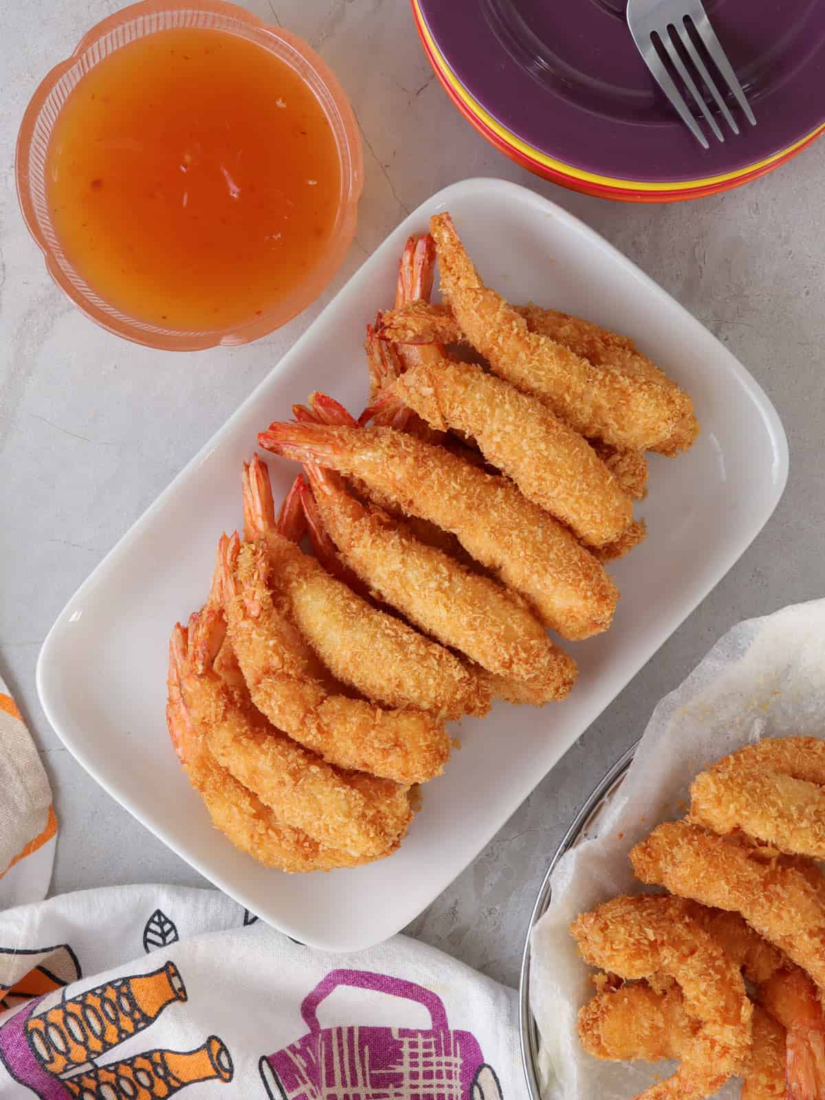 Coconut Shrimp on a serving platter with a small bowl of sweet chili sauce on the side