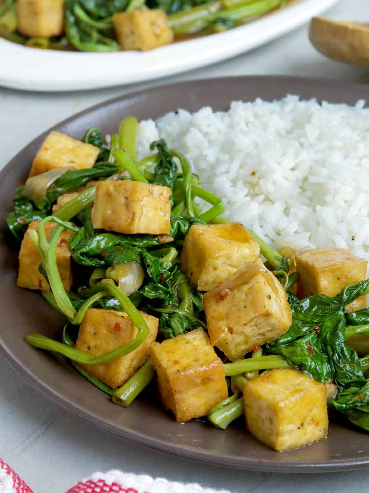 kangkong and tofu stir-fry with steamed rice on a plate