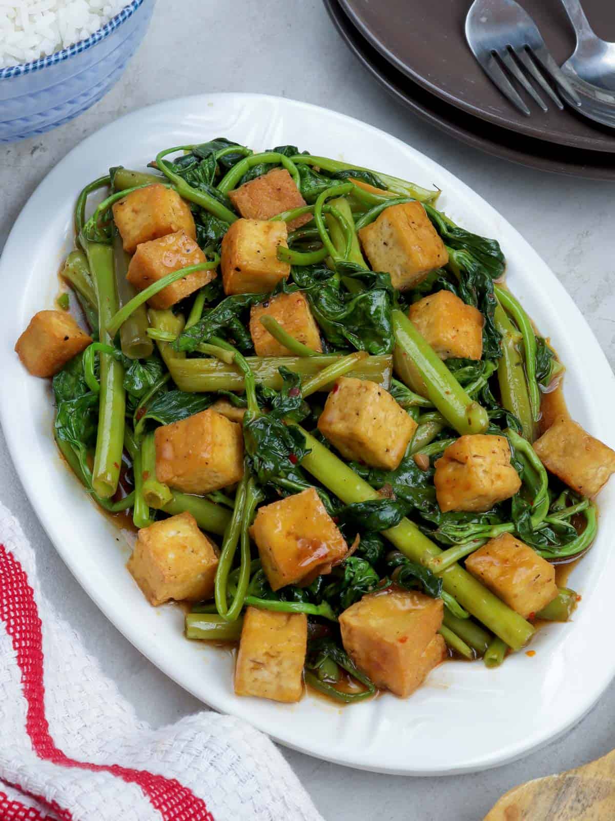 Kangkong and Tofu with Oyster Sauce on a white serving platter