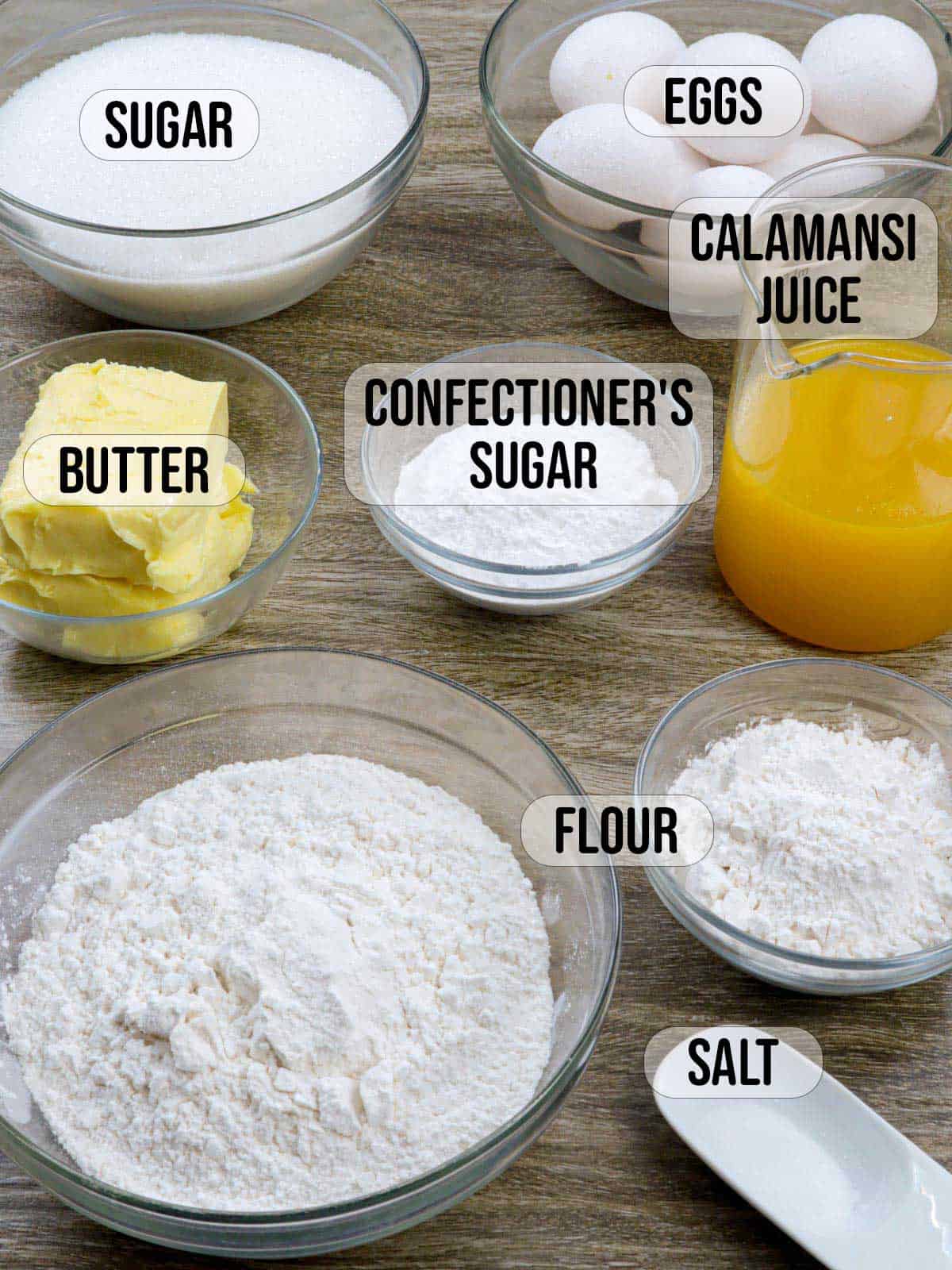 flour, sugar, powdered sugar, butter, eggs, salt, calamansi juice in bowls.