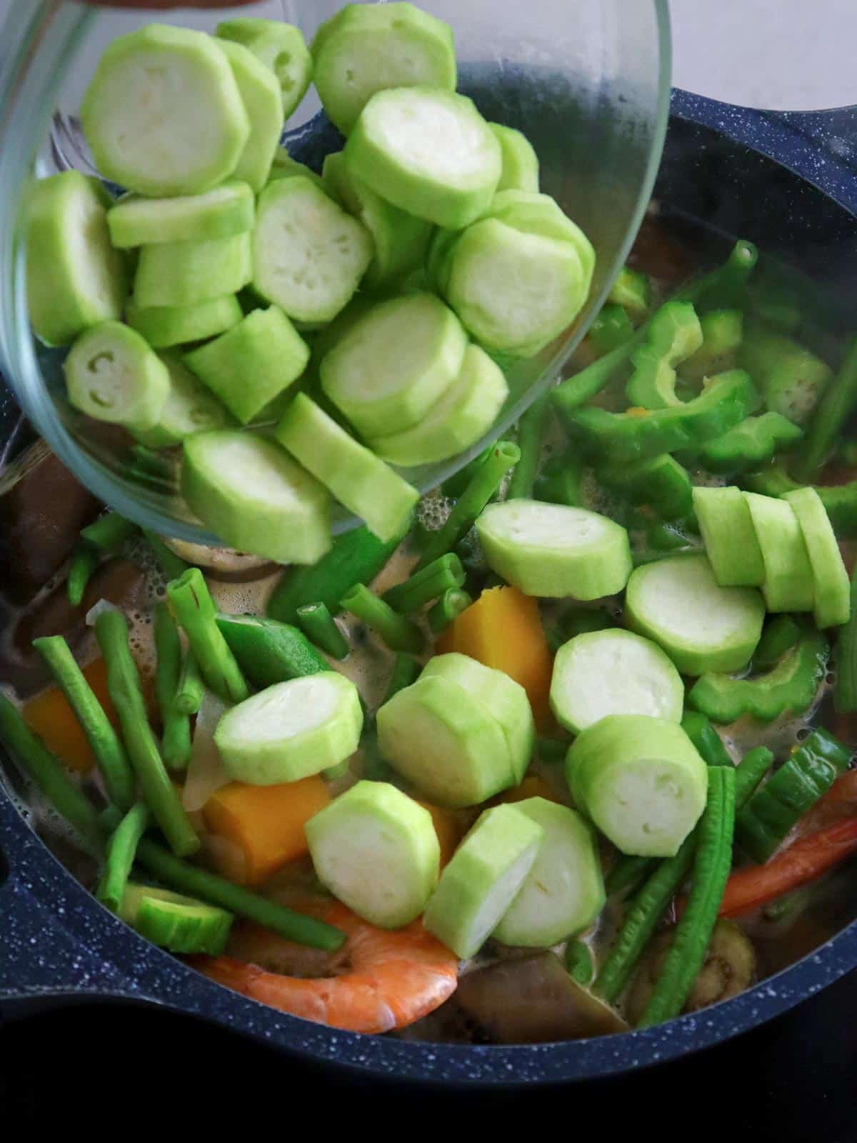 adding patola to a pot of laswa