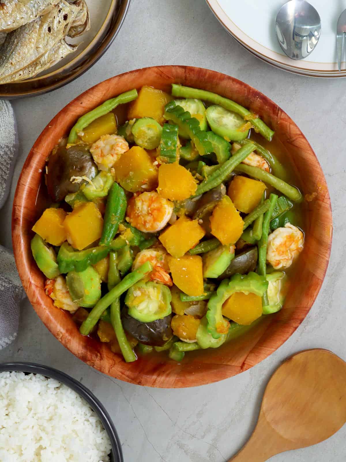 Filipino vegetable stew in a bowl with fried fish and steamed rice on the side