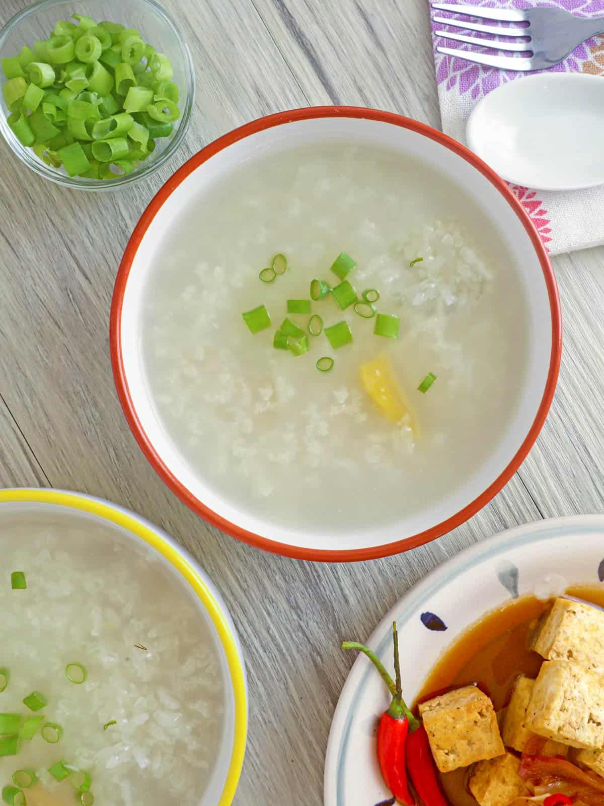 lugaw in a bowl with sizzling tofu on the side