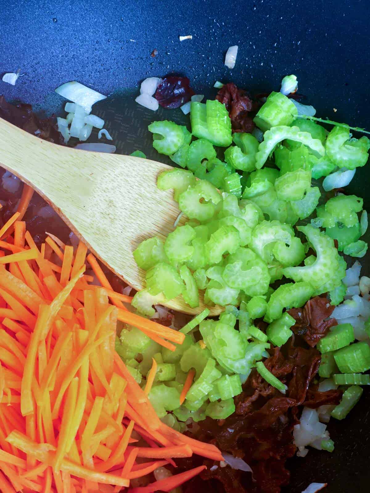 stir frying vegetables in a pan for pancit