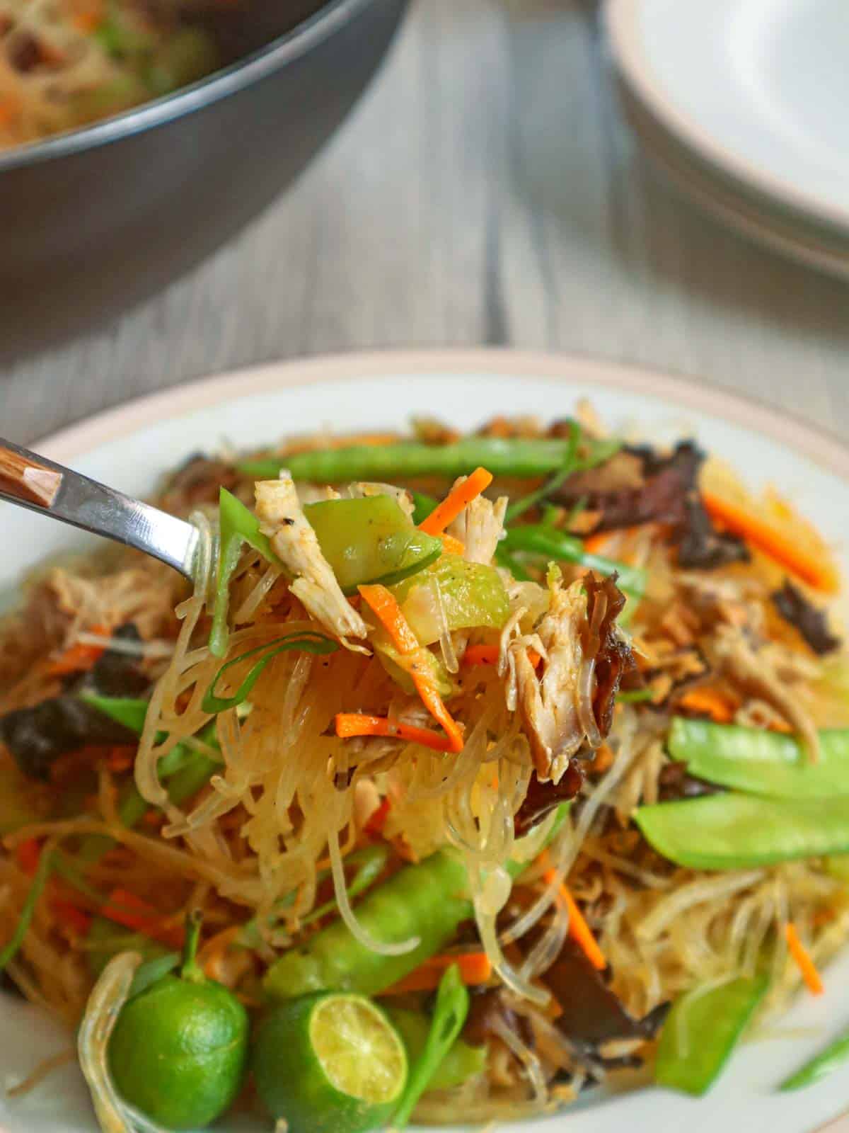 eating sotanghon guisado with a fork on a plate