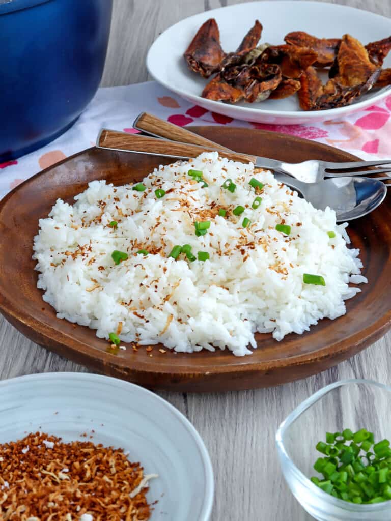 coconut rice on a serving plate with fried fish on the side