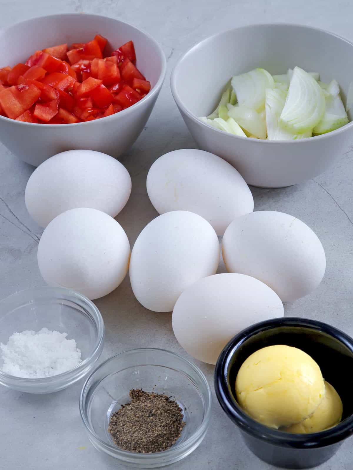 eggs, chopped tomatoes, sliced onions, salt, pepper, butter