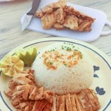 grilled chicken on a plate with steamed rice on the side