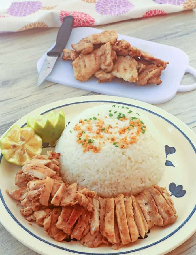 grilled chicken on a plate with steamed rice on the side