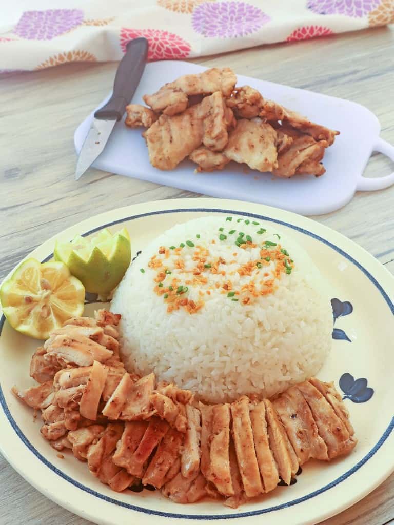 grilled chicken on a plate with steamed rice on the side