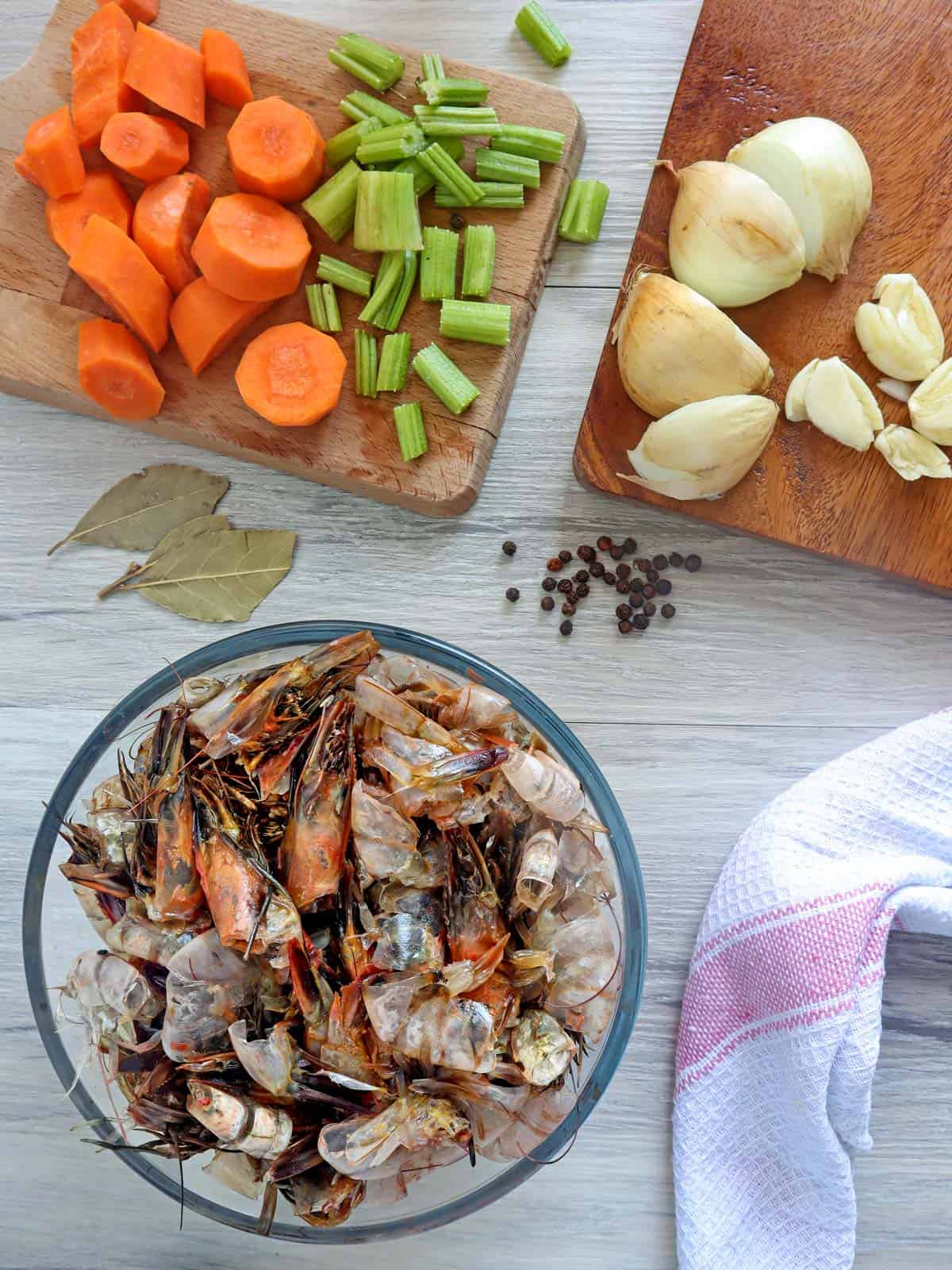 shrimp heads and peels, quartered onions, chopped carrots, celery, peppercorns, bay leaves, garlic 