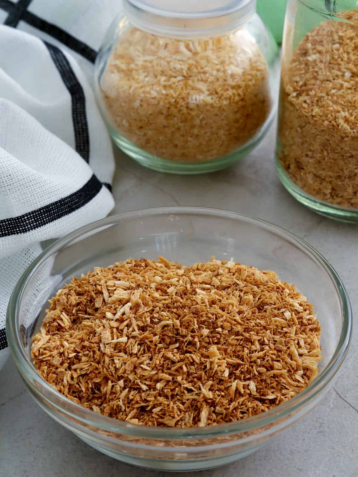 toasted coconut flakes in jars and bowl