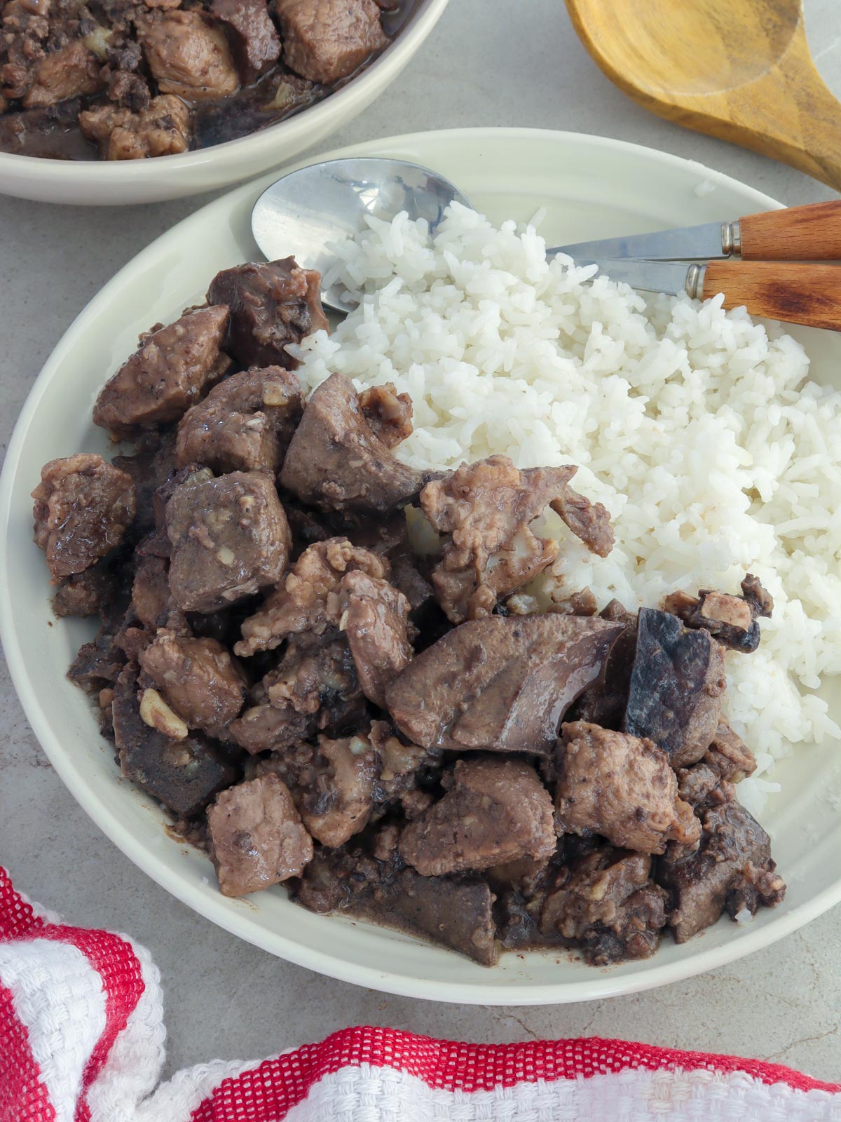 Kapampangan pork and liver stew on a white plate with steamed rice