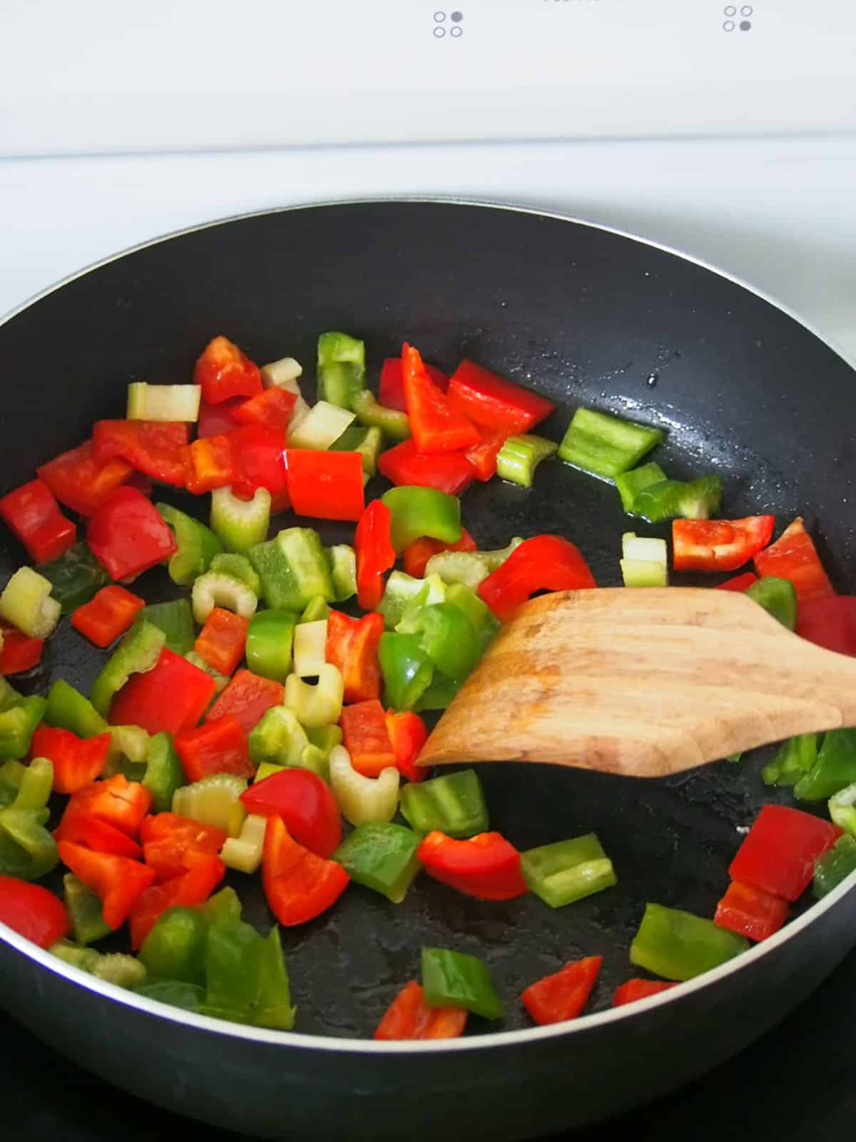 sauteing bell peppers in a wide pan