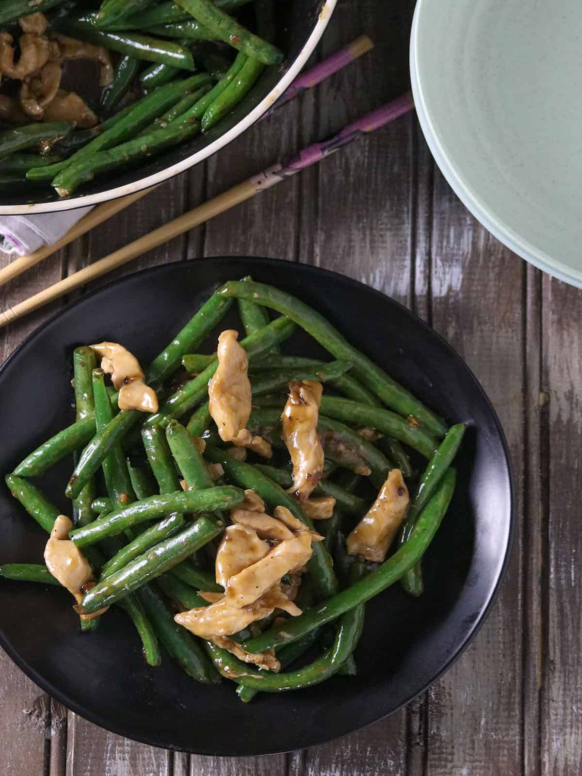 string bean chicken stirfry on a black serving plate