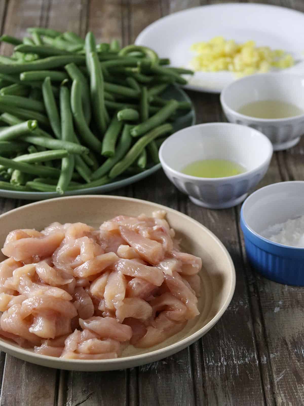 sliced chicken, green beans, garlic, ginger, oil, egg white, cornstarch in bowls