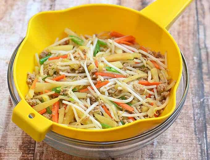lumpia filling made with ground pork, green beans, kamote, bean sprouts, and carrots in a yellow colander