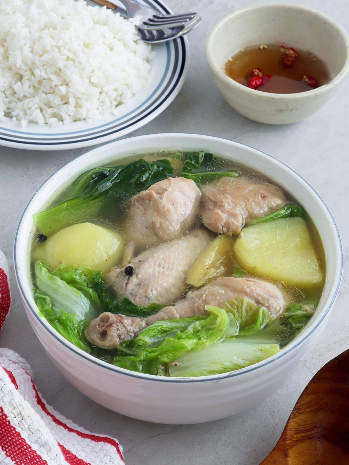 Pesang Manok in a serving bowl with a side of steamed rice and fish sauce