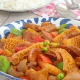 ox tripe stew with garbanzo beans, green peas, and bell peppers in a blue serving bowl