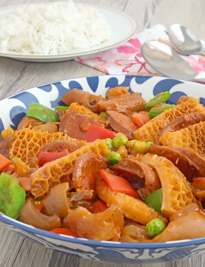 ox tripe stew with garbanzo beans, green peas, and bell peppers in a blue serving bowl