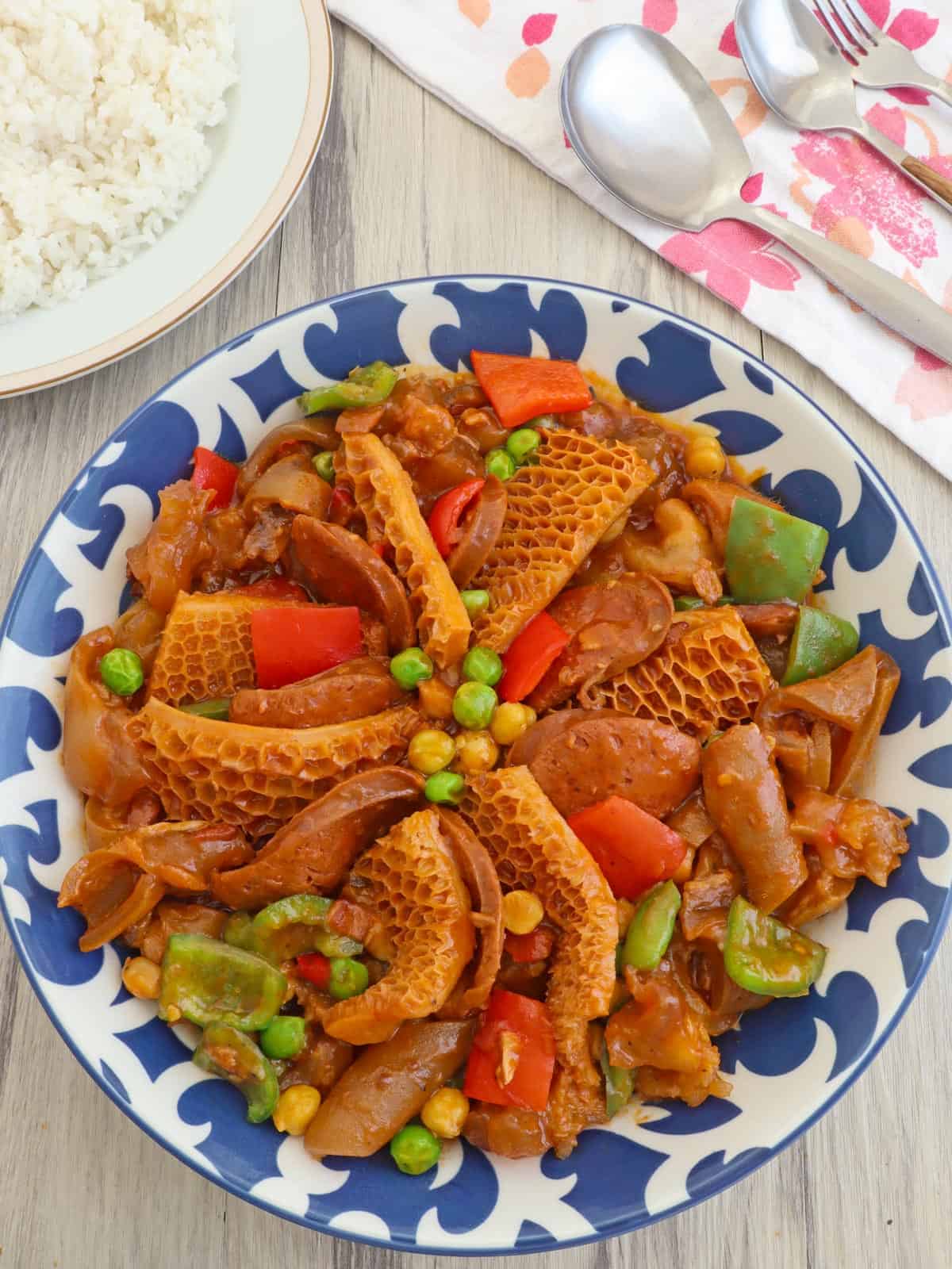 Callos in a serving bowl with a side of steamed rice