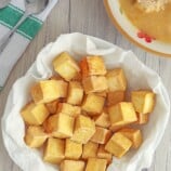 crispy tofu cubes in paper lined bowl