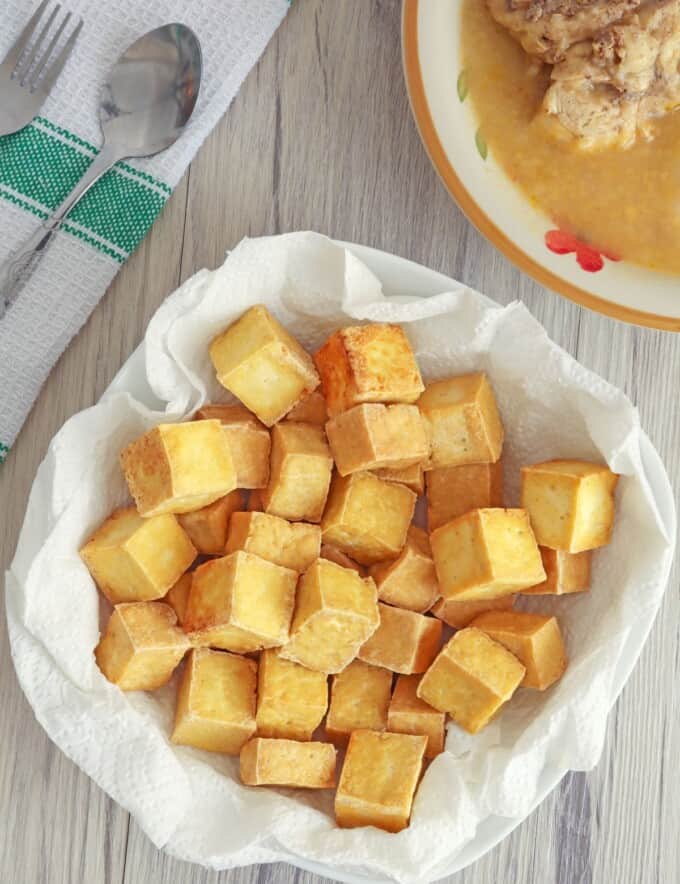 crispy tofu cubes in paper lined bowl