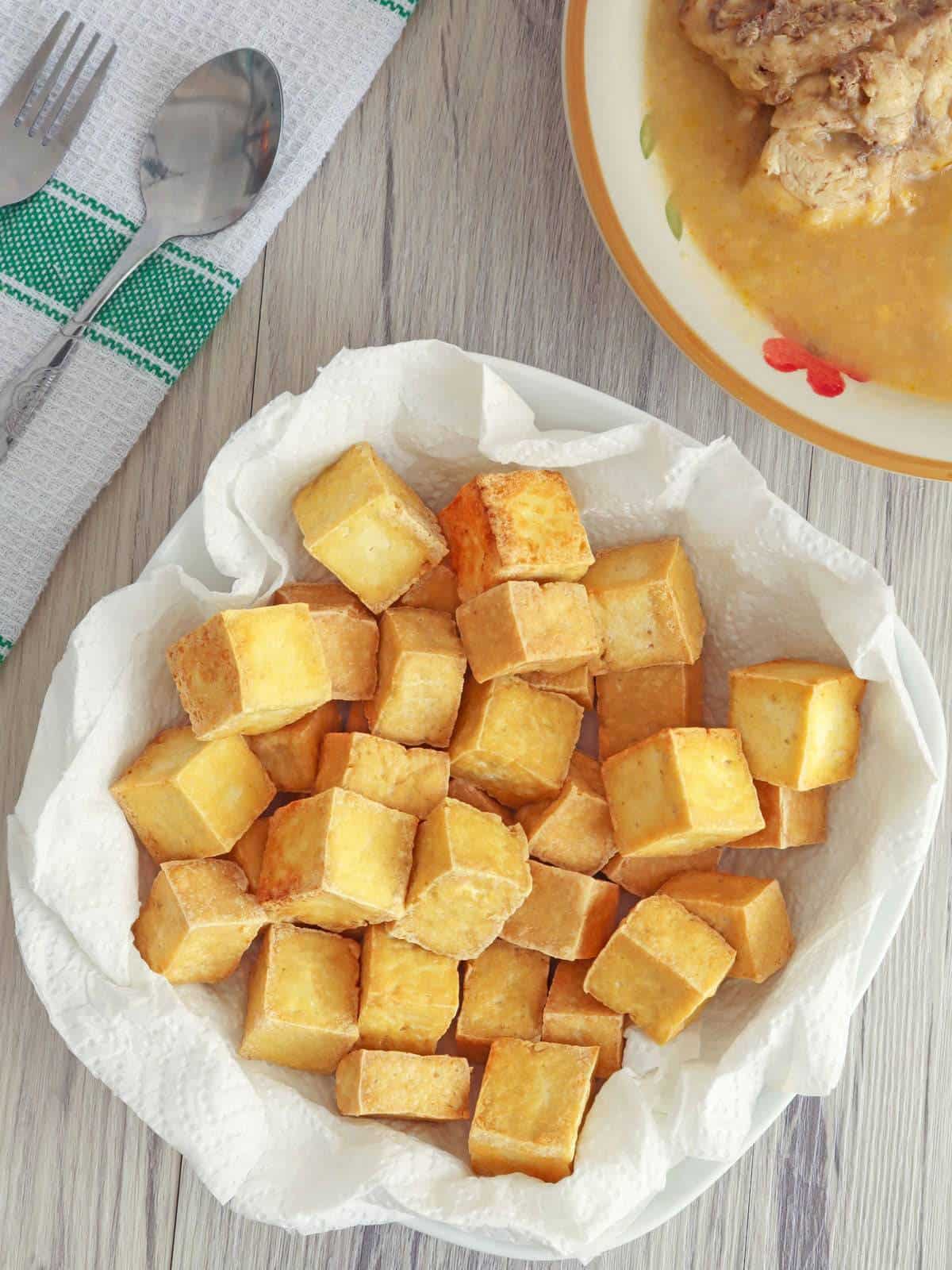 crispy tofu cubes in paper lined bowl