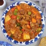 Kalderetang Kambing in a blue serving bowl