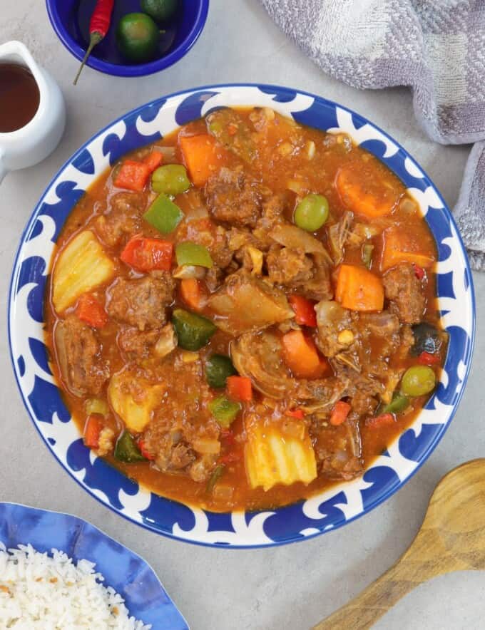 Kalderetang Kambing in a blue serving bowl