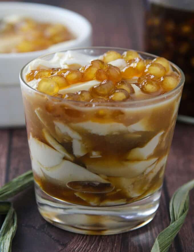 Taho in a clear glass with brown syrup and sago