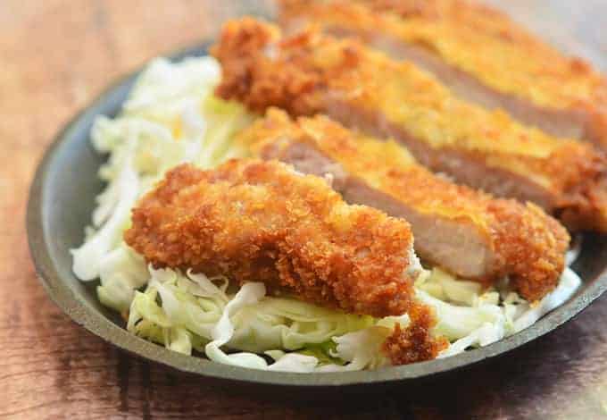 These golden brown fried pork chops are moist and served with fresh cabbage.