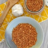 toasted garlic bits in a bowl with a whole garlic head on the side