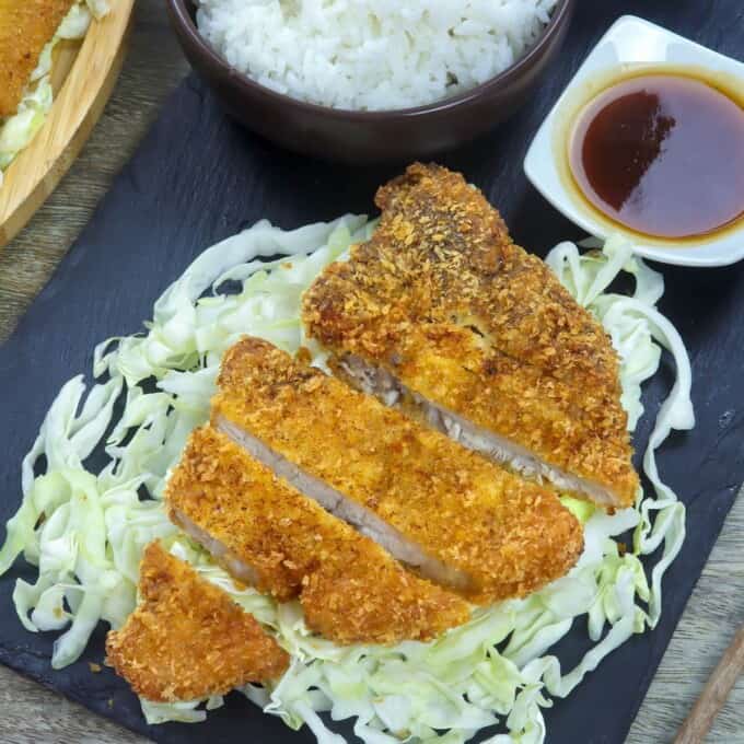 tonkatsu over shredded cabbage with a side of steamed rice