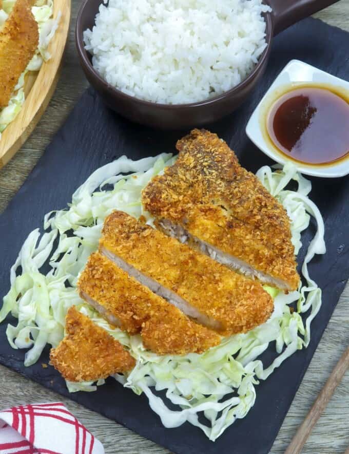 tonkatsu over shredded cabbage with a side of steamed rice