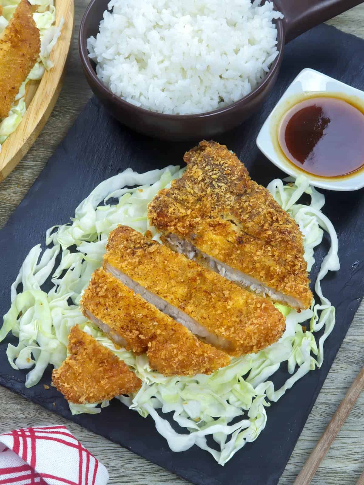 tonkatsu over shredded cabbage with a side of steamed rice