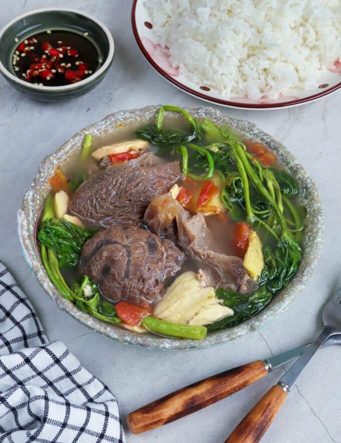 Sinigang na Baka sa Bayabas in a serving bowl with a plate of steamed rice and a dish of patis on the side