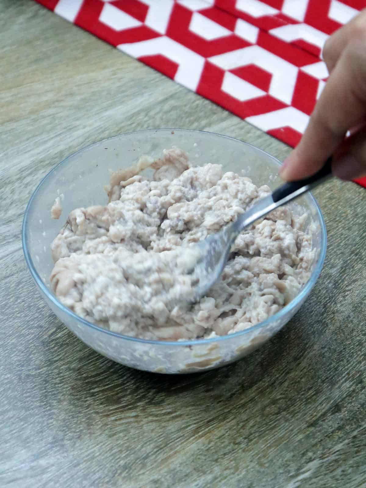 mashing pork brain in a bowl